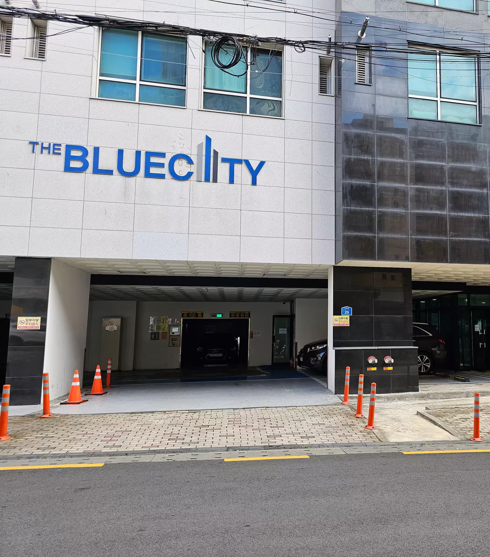 THE BLUECITY 간판과 주차장 입구가 보이는 건물 1층